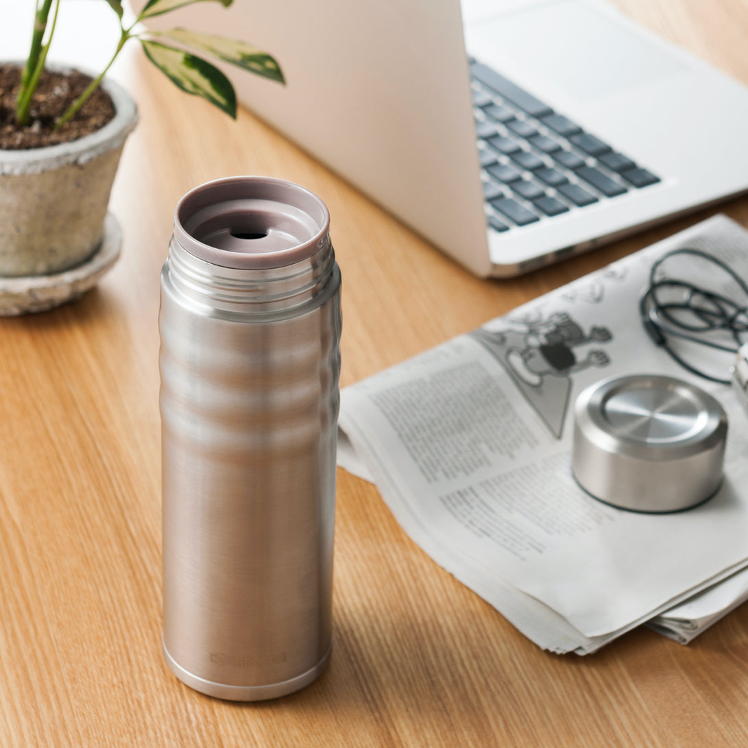 KYOCERA Ceramic Coated Twist Top Thermos offered by Wild Orchard Tea, image of thermos on a desk